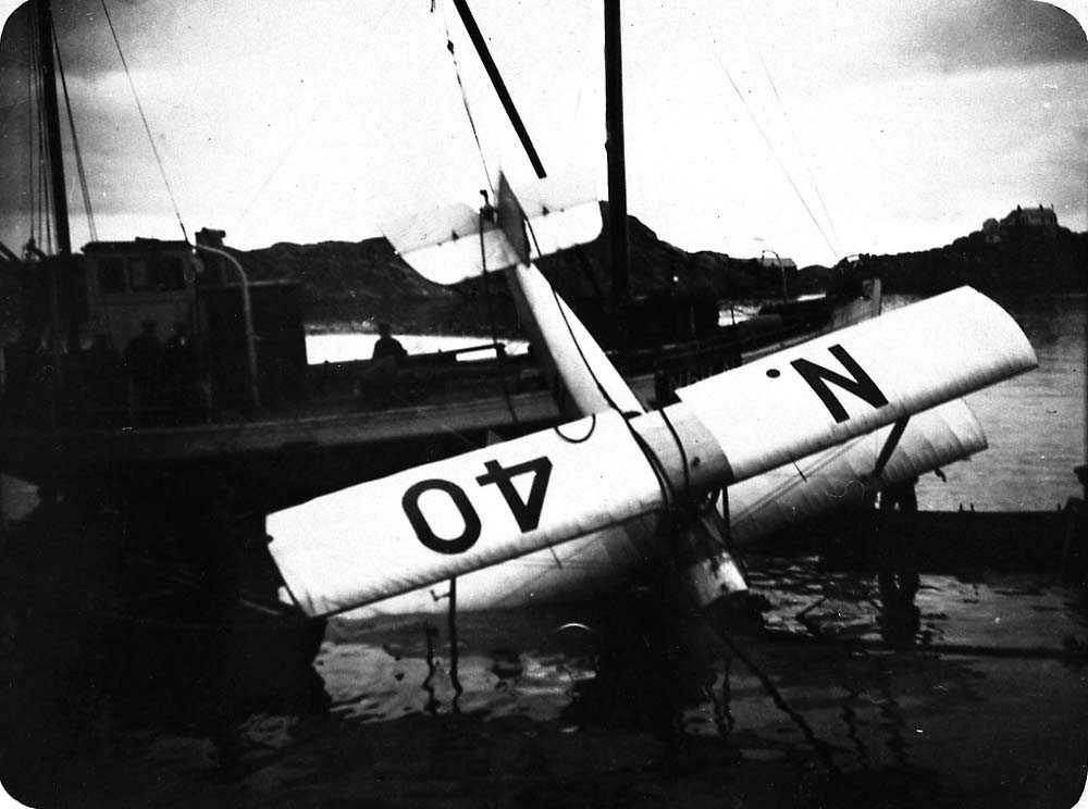 Ett sjøfly som blir heist opp av vannet etter et havari, Saaski "Måsen".
En båt med flere personer ombord.