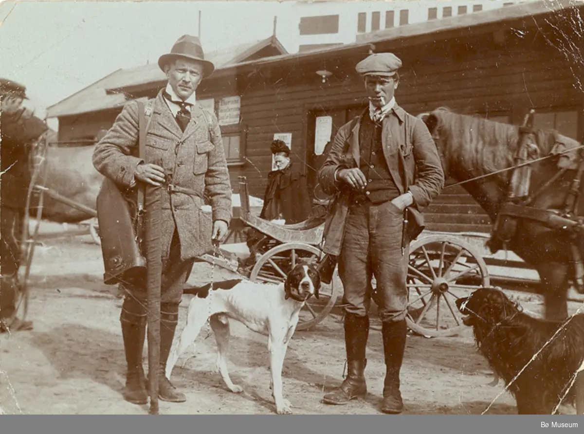 To menn klare for å dra ut på jakt/eller har vore på jakt.
Mannen t.h. er Halvor G. Staurheim, Bø.  Bildet er tatt på Notodden.