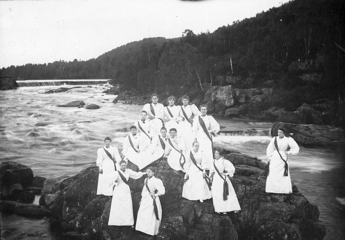 Oskarströms sn. Kvinnor i fina klänningar på en sten vid älven.