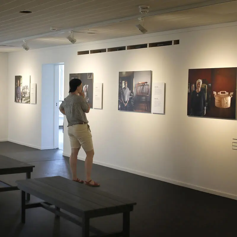 Fra utstillingen "Opphavstegn" på Norsk utvandrermuseum. En person ser på utstillingens fotografier