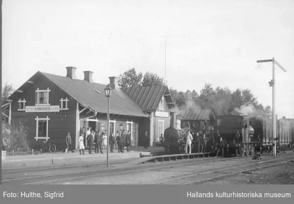 Ånglok med godsvagnar vid Kinnared Järnvägsstation. Stationen invigdes 1877 då sträckan Halmstad-Värnamo var klar. 1885 anlades järnvägen mellan Kinnared-Fegen och 1887 var sträckan Fegen-Ätran klar. Så när Varberg-Ätrans Järnväg invigdes 1911 kunde man fortsätta resan ända till Kinnared. Bilden är tagen före 1915 och signerad Sigfrid Hulthe, Öster, Halmstad.