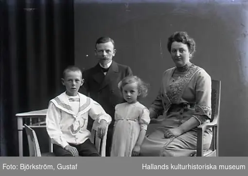 Ateljébild. Familjebild, föräldrar med en liten flicka och en pojke i 3/4 figur. Beställare: Stationsskrivare Helmer.