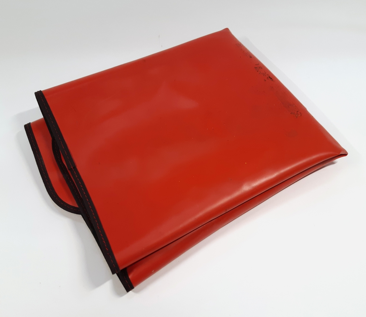 ESD Servicekit, bestående av en ihopvikbar och antistatisk arbetsmatta i röd plast. Samt en oöppnad materielpåse, innehållandes ett handledsband och en jordningskabel med krokodilklämma. Medföljer en instruktionsmanual gällande ESD Servicekit.