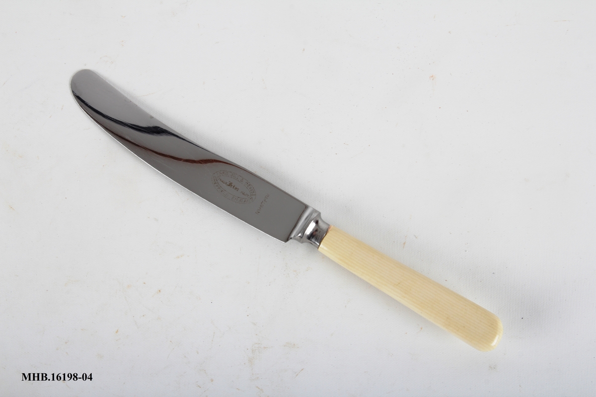 Kniv med plastskaft og rett knivblad med avrundet avslutning.