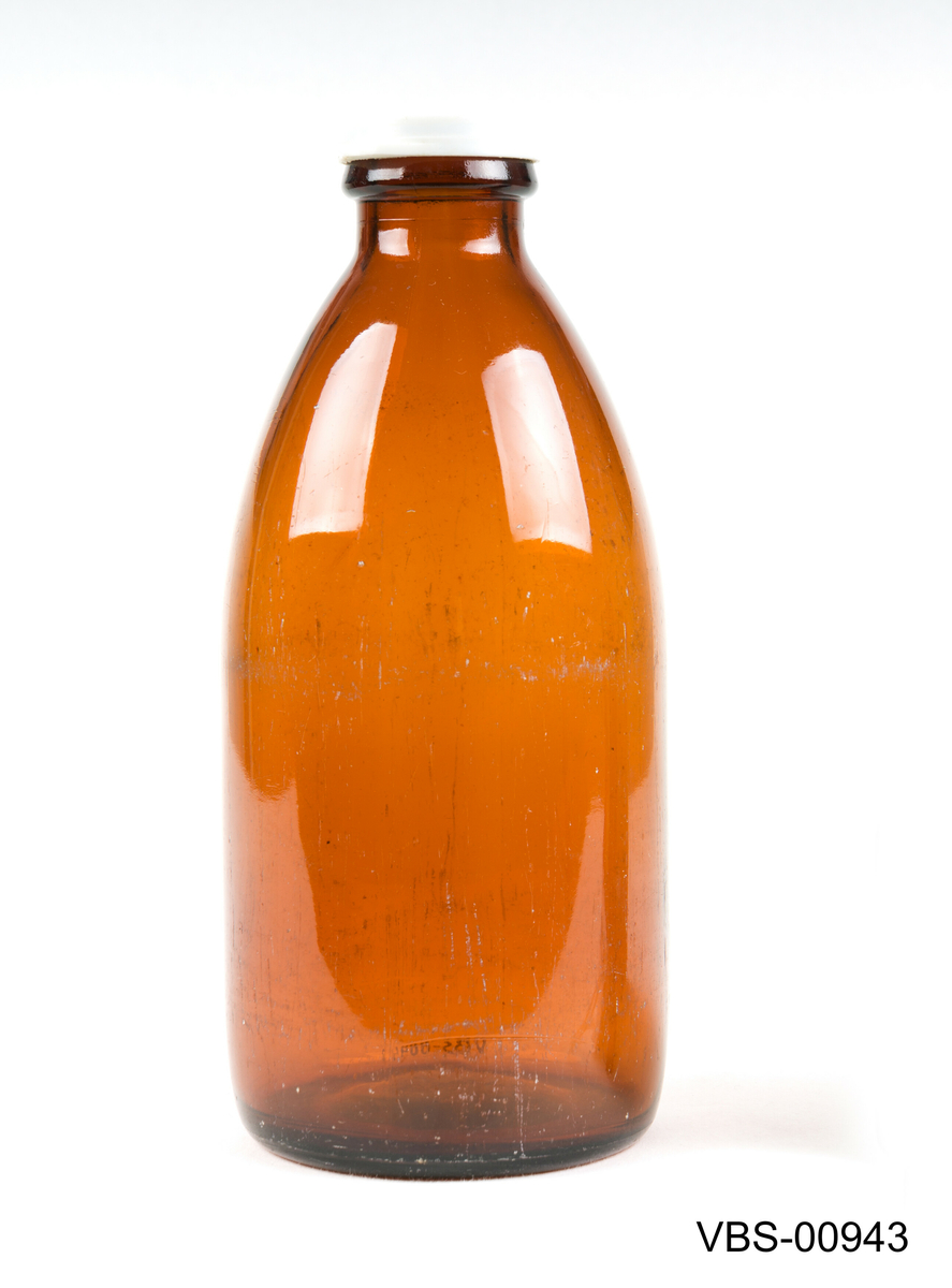 Avrunded brun glassflaske som melkeflaske med et lokk i plast.