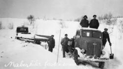 Malmbil fast i snøen, 1938. Flere menn med spader står rundt
