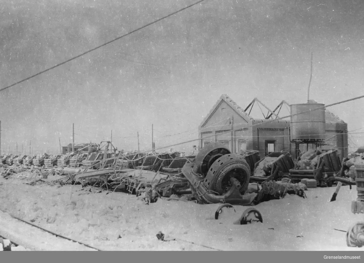 Gruvene i Bjørnevatn vinteren 1944/45, sett fra bensinstasjonen. Ruinene av baneomformeren og vanntårnet. Grovknuserverket i bakgrunnen.