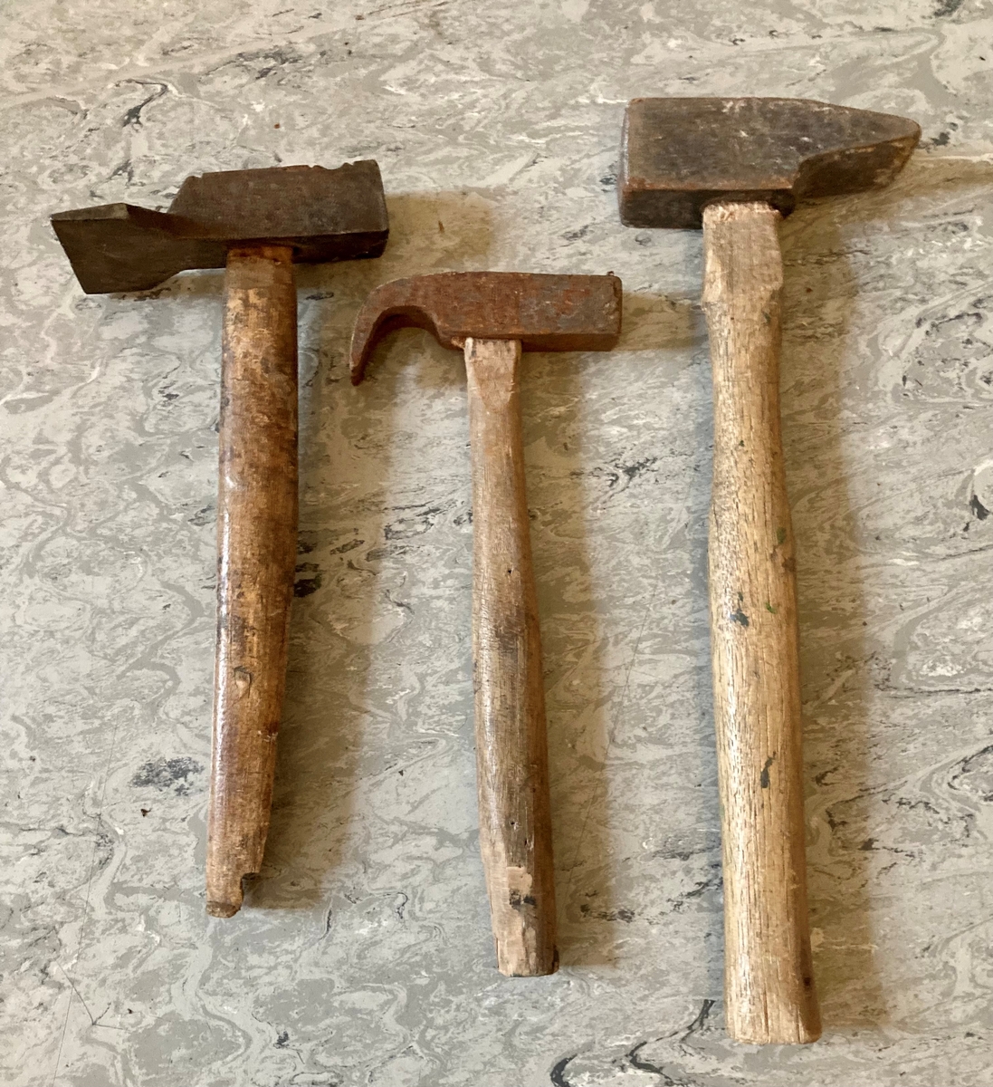 En samling av verktøy. Inneholder: en treklubbe, fem hammere i ulike størrelser, fire borvinner, en bunt med tau, en kjørner, en fil, en sponhøvel, en saks, to vinkelmålere.