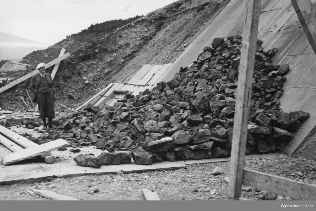 Tipping av malm ved utskipnigskaia i Burfjord august 1937. En mann i dress står nedenfor å ser på.