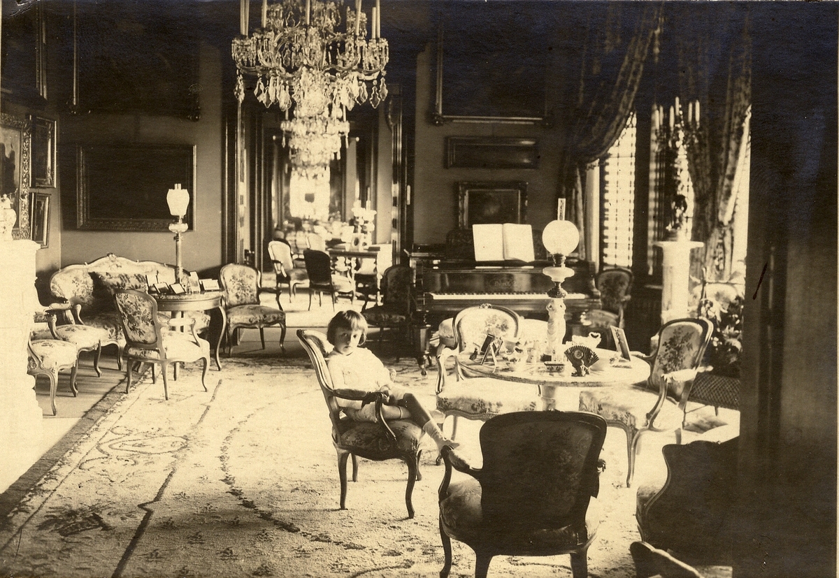 Pojke sittandes i salongen på Teleborgs slott. Cirka 1916.
