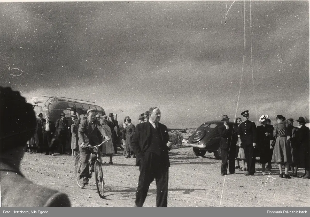 Åpningen av Tana bru i august 1948. Åpningsseremonien er over. Vegsjef Harald Hofseth er midt på bildet, rundt ham er det mange mennesker. Se også de andre åpningsbildene 346 358.