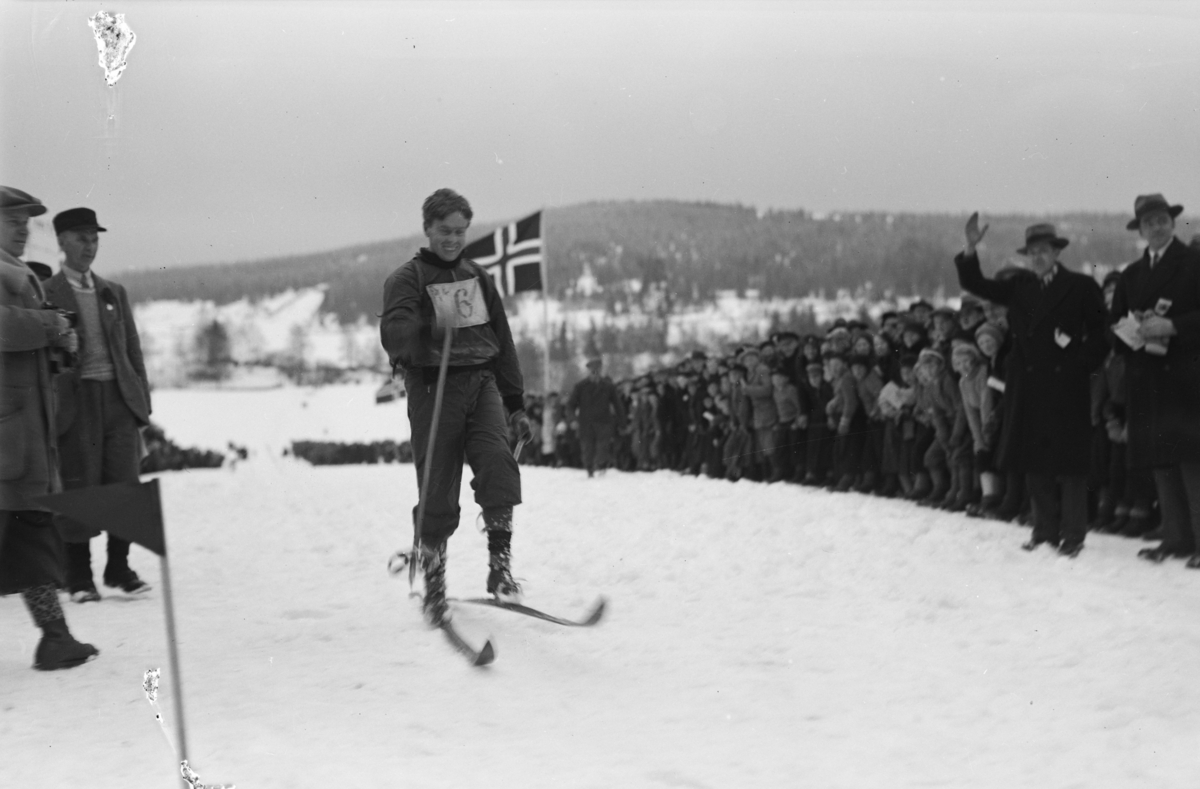 Birkebeinerrennet, start nummer 6 på veg mot mål på Lysgårdsjordet i Lillehammer, tilskuere og arrangører følger med.