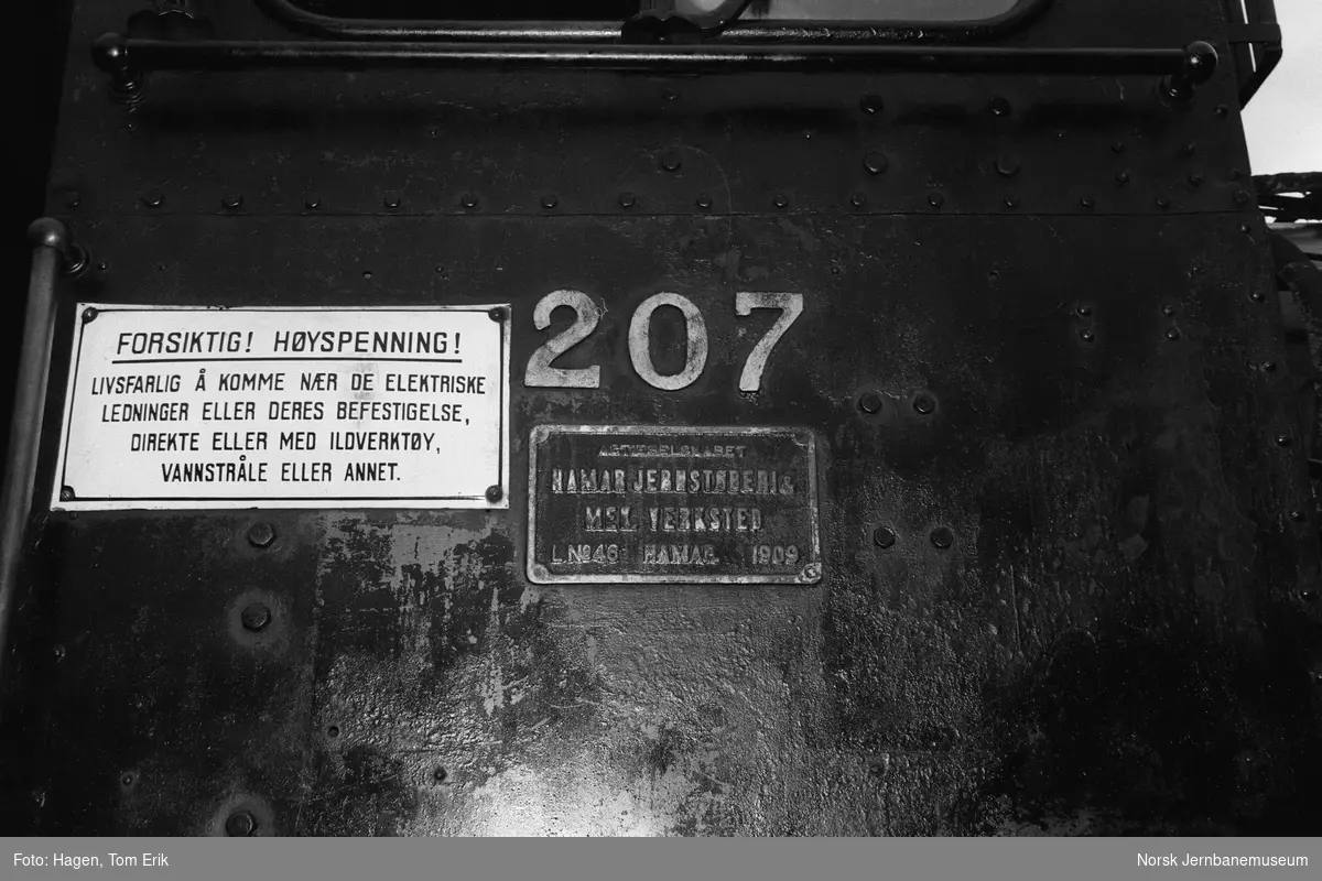 Fabrikk- og nummerskilt på damplokomotiv 21e 207 utenfor lokomotivstallen på Hamar