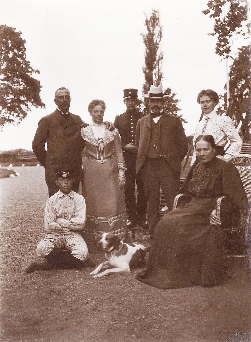 En grupp människor, däribland landssekreterare Frithiof Ohlsson, Växjö, med hustru Elfrida och sonen Torsten, 
poserar för fotografen på en gårdsplan, ca 1910.