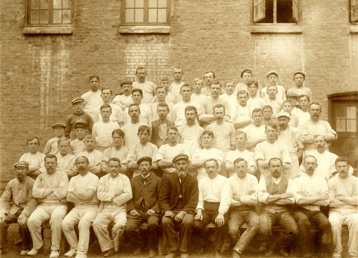 Gruppeportrett av ansatte ved Porsgrund Poreselænsfabrik, fotografert av H. Dahl Kristiania, 1911.
