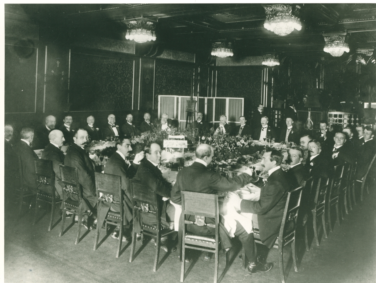 Bildet kan være fra et møte i Høvellast-Exportforeningen. Emil Mørch (1850-1921), sitter midt på ved bordet langs veggen.