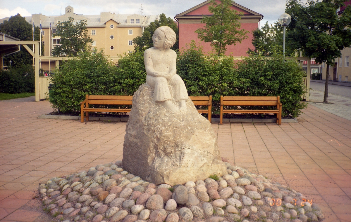 Skulptur med människa på sten, placerad på ett litet torg i Bollnäs, 24 juli 2000.