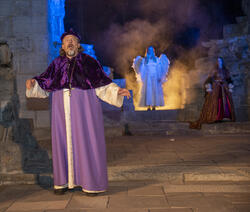 Biskop Mogens hører spøkerier i kirka, en engel skinner i bakgrunnen.