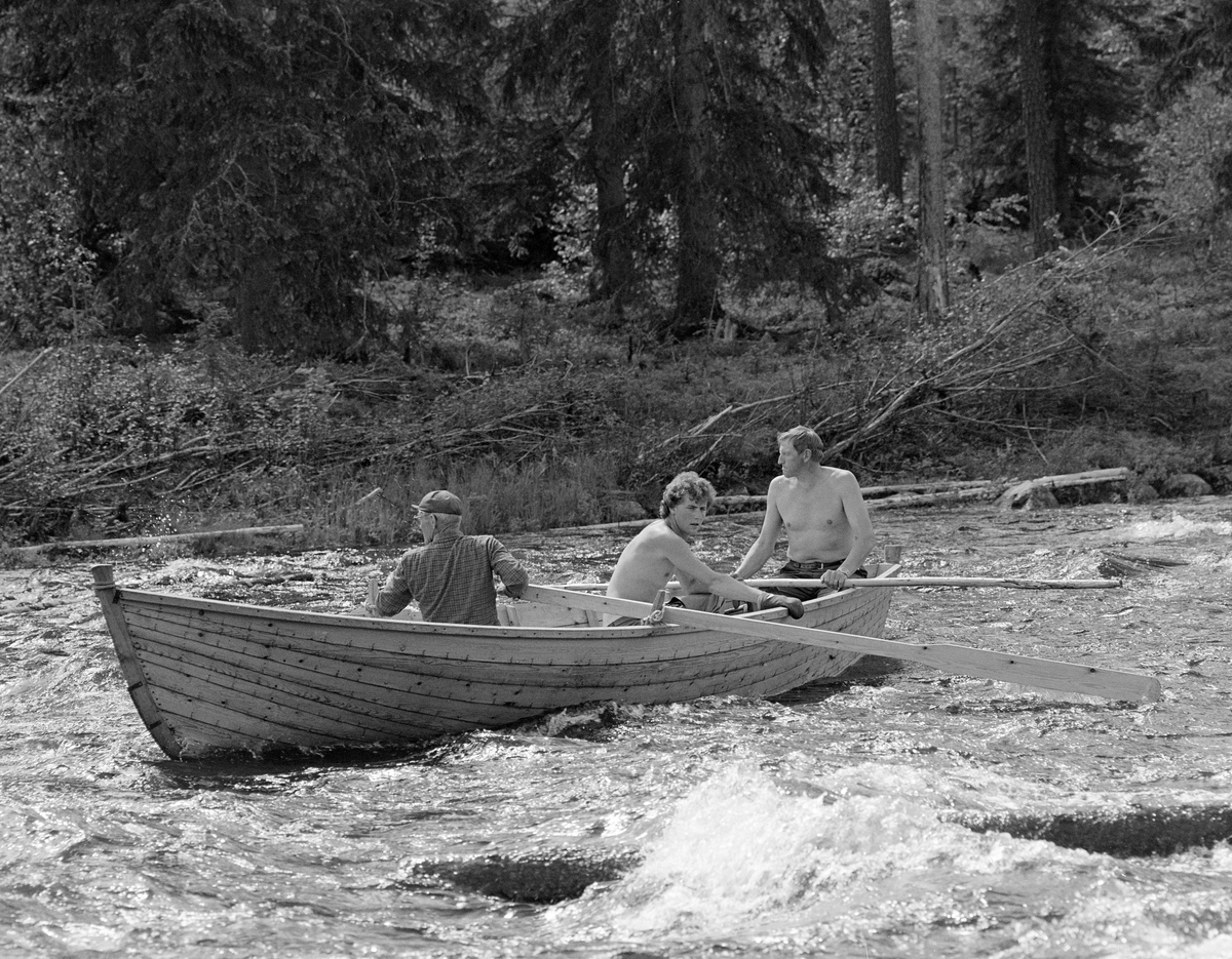 Sluttrensk i elva Stor-Grøna i Trysil, Hedmark. Fløtere i robåt på vei ned elva.