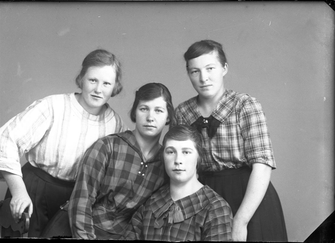 Gruppbild med fyra flickor/unga kvinnor tätt tillsammans. Tvåa från vänster är Hilma Carlsson från Hestra, Vireda.