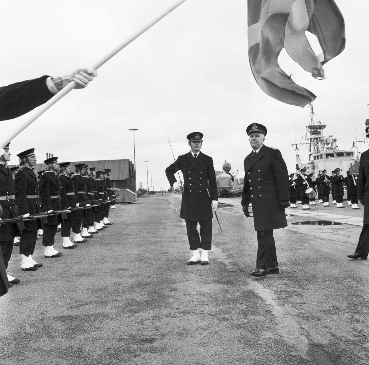 Bilden visar den före detta marinchefen, amiral Åke Lindemalm som står fram för en rad soldater som har tagit uppställning för sjösättningsceremonien för torpedbåten Varberg.