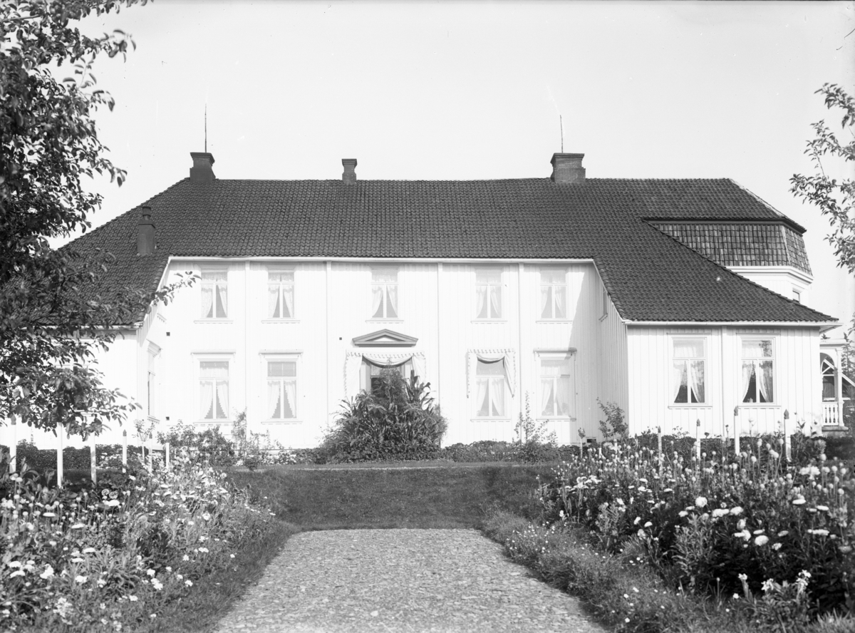Samling fotografier knyttet til Borgestad Gård, Gunnar Knudsen. Fotograf John Nielsen. Motiv med fasade med haven i forkant, Borgestad gård.