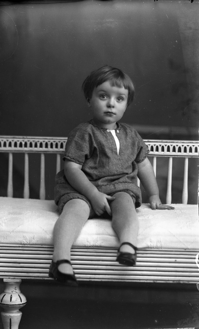 Porträtt av ett litet barn som sitter i en soffa av gustaviansk stil.