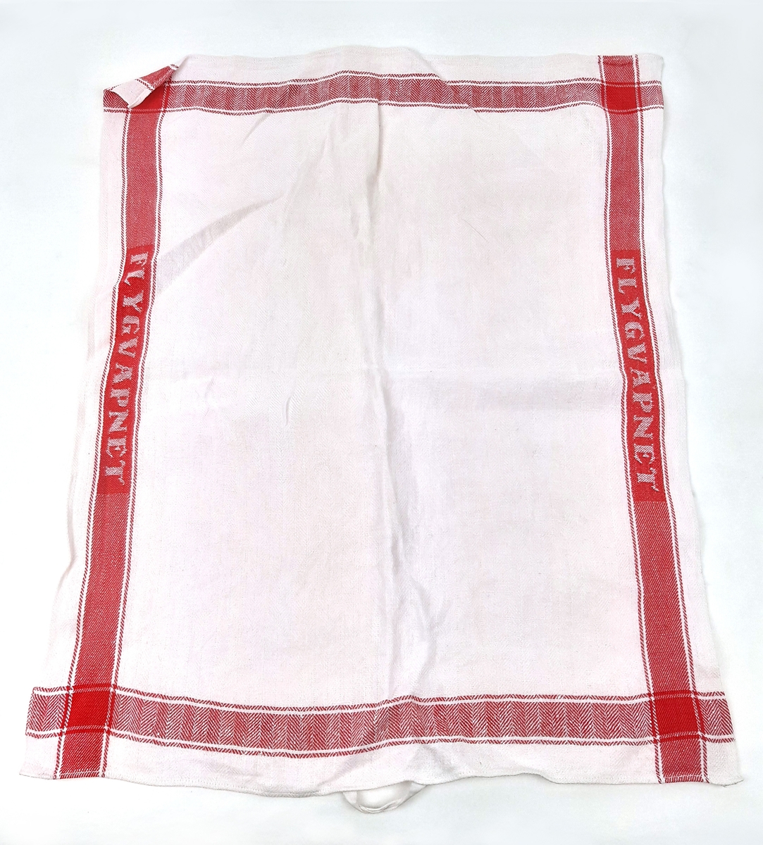 Linnehandduk i vit textil med röda bårder, samt invävd text "FLYGVAPNET".
