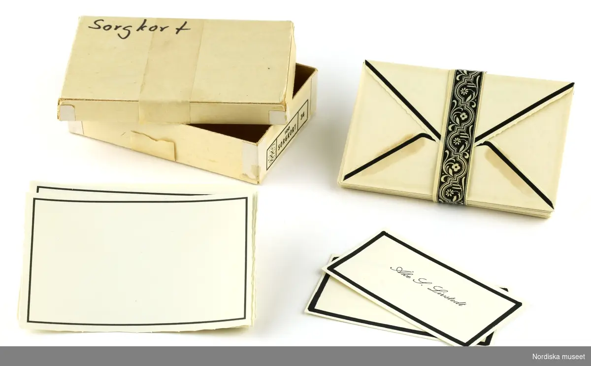 Pappersask med 17 kuvert ombundna med ett mönstrat pappersband, 22 kort med naggade kanter och 2 visitkort, samtliga med svart kant. 
/Magdalena Fick