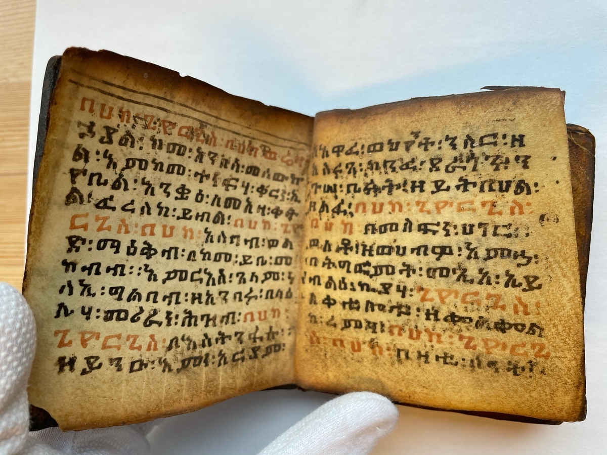 Amharisk bönbok. Textat med svart och rött på pergament. Läderpärmar.