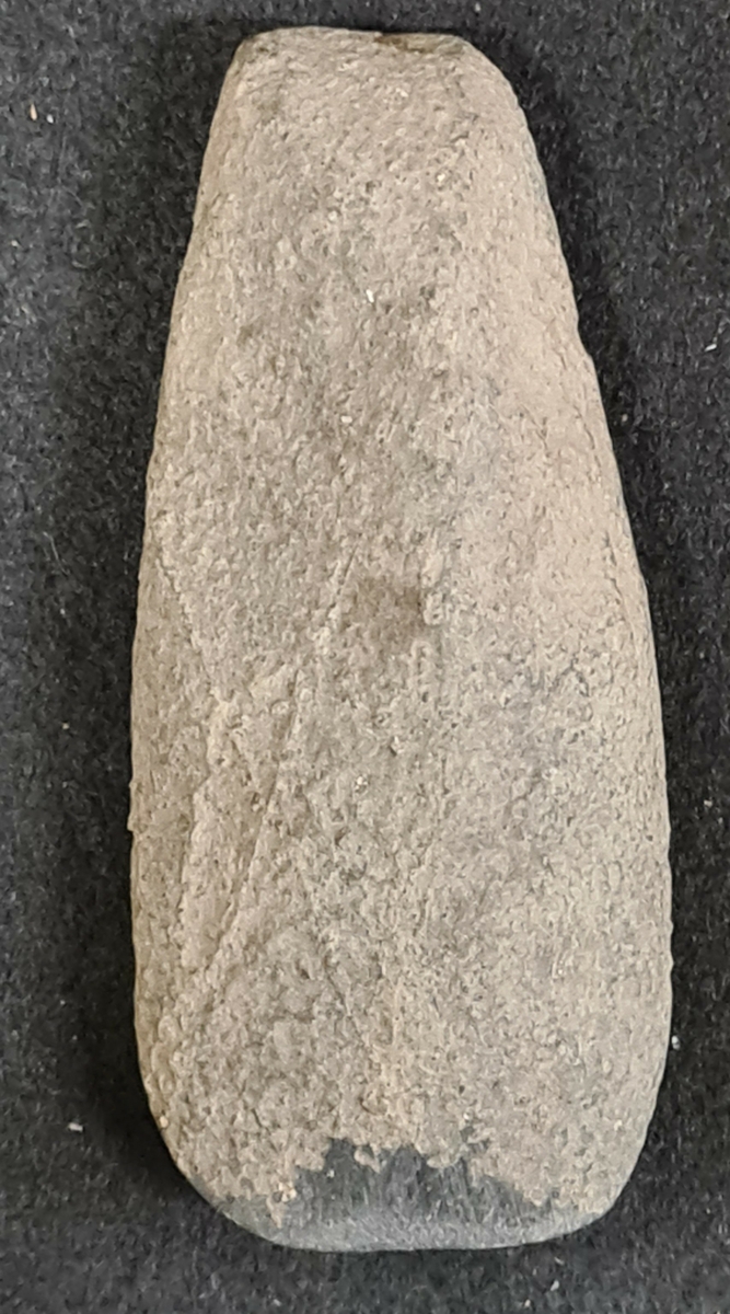 10 511. Från Erikstorp, Berga socken, Västergötland.

Yxa bergart, Lihultstyp, 1 st. 3-sidig genomskärning, slipad. Vittrad. L. 10,5 cm, Bredd 4,5 cm.