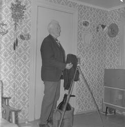 Fotograf Willum Ekrheim med fotoutstyret sitt heime i stova 