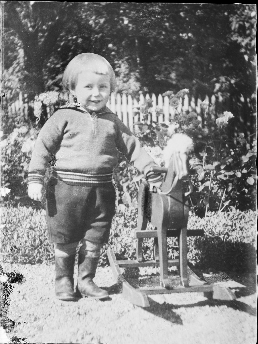 Pojke i trädgården med gunghäst, Östhammar, Uppland