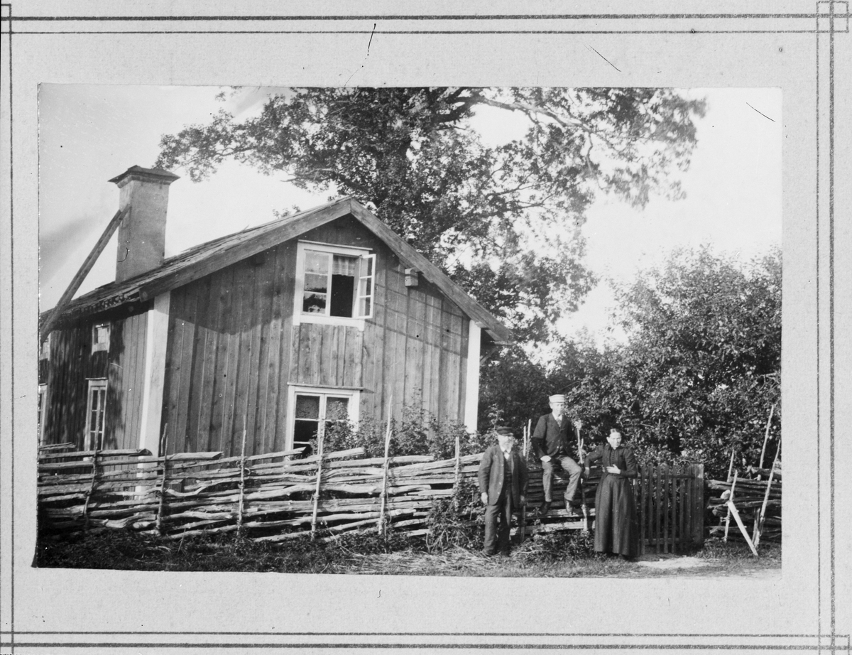Reprofotografi - män och kvinna vid staket utanför bostadshus, Östhammar, Uppland