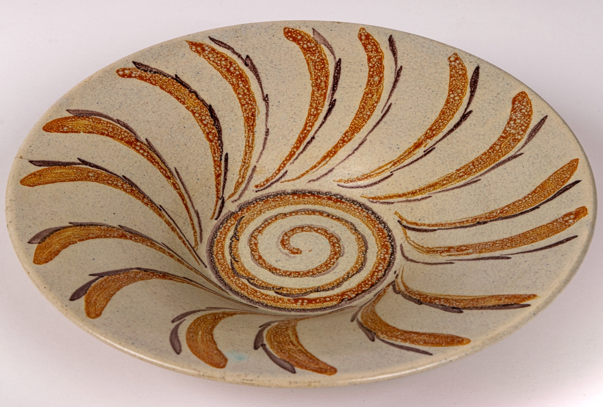 Handmålad skål i modell 4308/4 med dekor OM; orange och brunlila böjda kvistlika former längs brättet samt i snäcklik form i botten.
