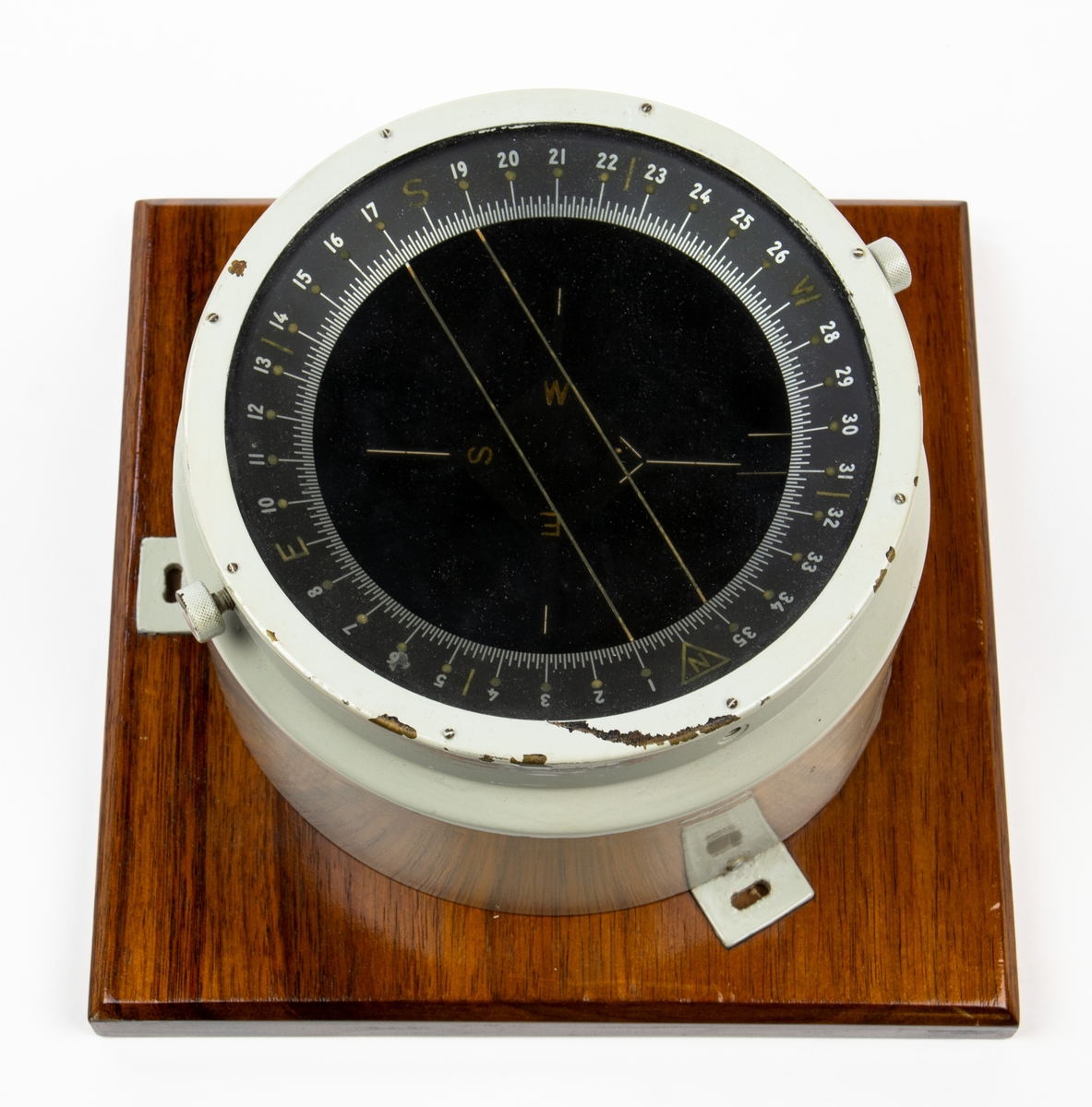 Kompass fastsatt på en träplatta med mått 228 x 228 mm. Kompassen är gyroupphängd. Troligen för flygplan