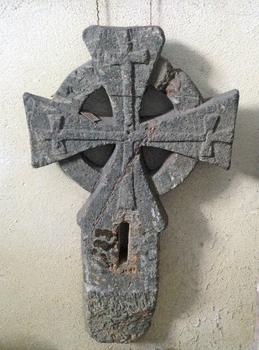Fra Hoels katalog (883):
Hjulformet gravkors av klebersten. Korsarmene buede og sterkt fremtrædende skaper hjulringen og prydede med mindre, retlinjede kors. Fra Melum kirke.