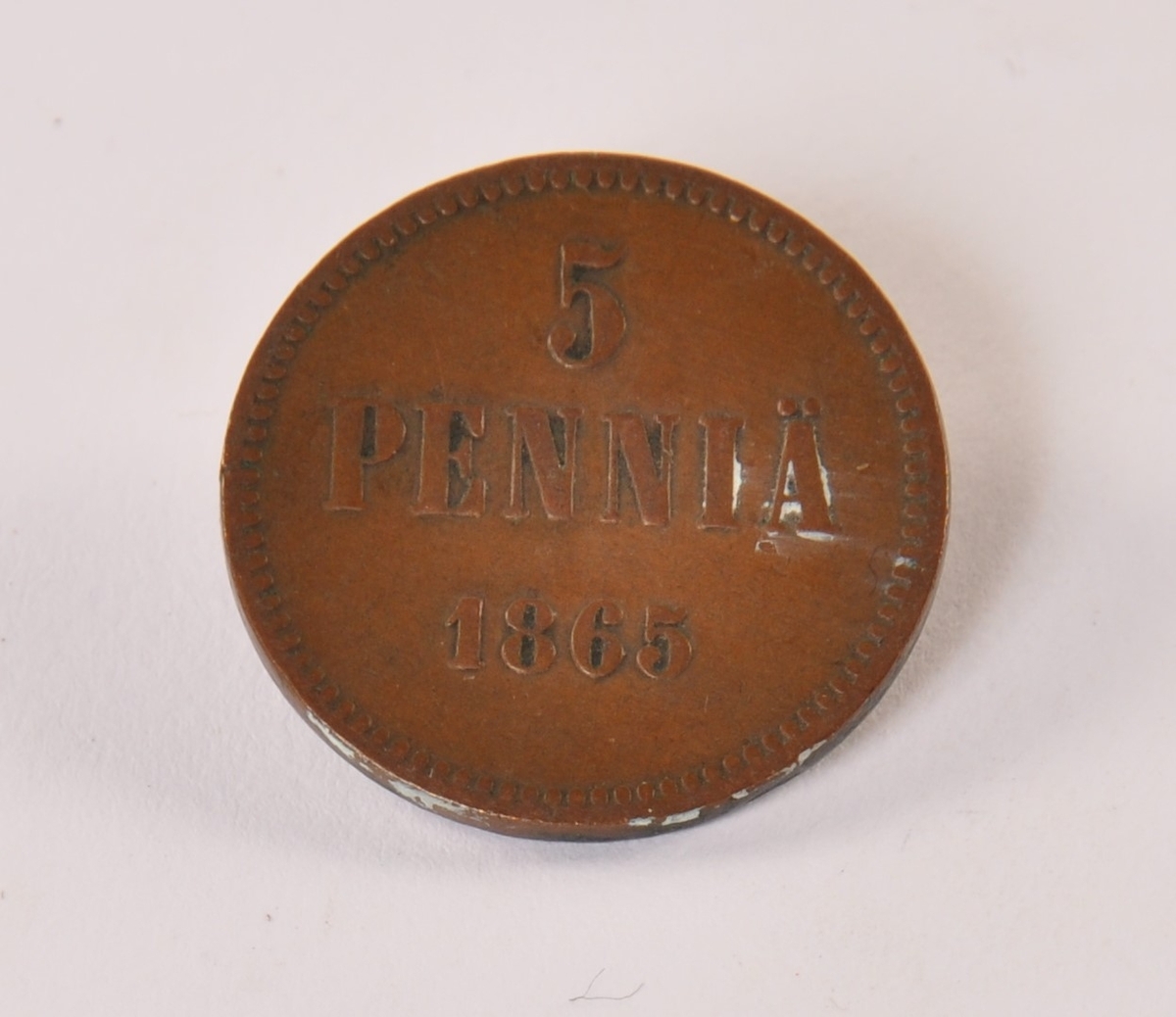 Finsk mynt av bronse. Reversen: 5 penniä 1865. Aversen: monogram Tsar Alexsander II