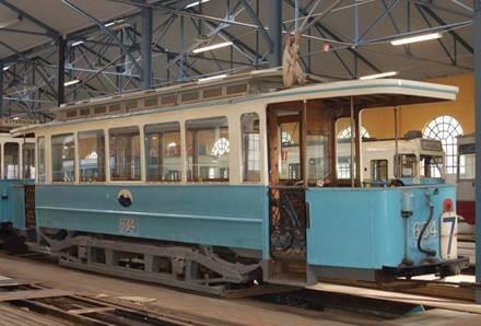 Sporvognstilhenger i lys blå og kremhvit farge fra 1924. Vognen har vognnummer plassert i front, bak og på langsidene. 