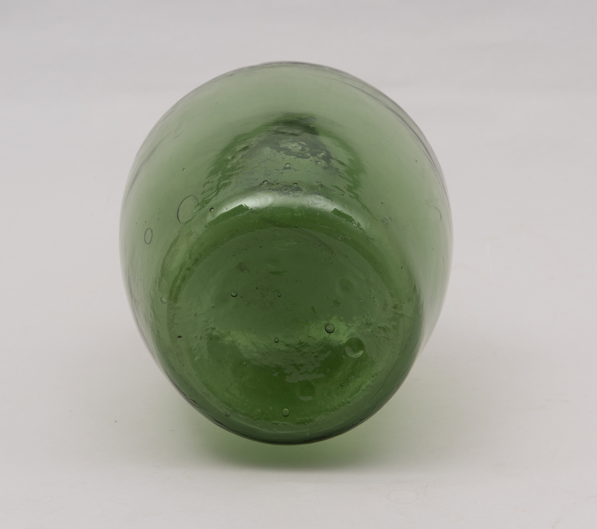 Grønn ballongformet flaske av glass.