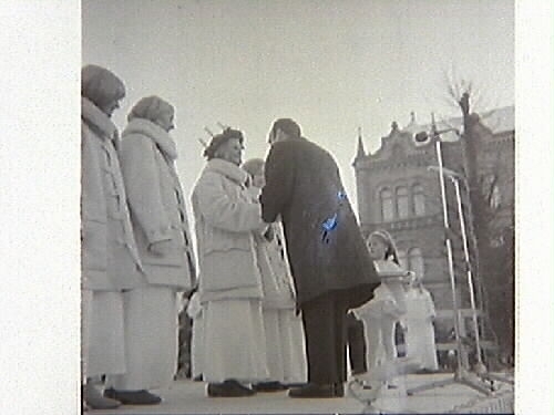Tidningsartikel med Tomteparaden på Varbergs torg med kröning av årets Lucia. Publicerat i Hallands Nyheter, 1967-12-11. Evenemanget spelades in av TV och sändes den 13 december. Bild G14930-14933 från torget, G14934 från Nöjesparken. Bild G14934 är publicerad i tidningen.