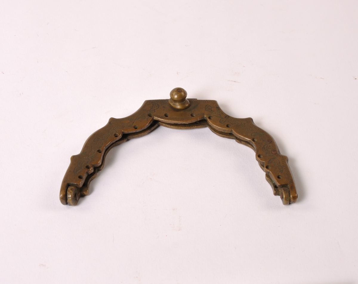 Halvsirkelformet lås til dameveske i kobber med innerdeler i jern. Dekorert med bladmønster.