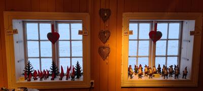 Smårutete vinduer med julenisser i vindusposten og filthjerter på midtstolepen. (Foto/Photo)