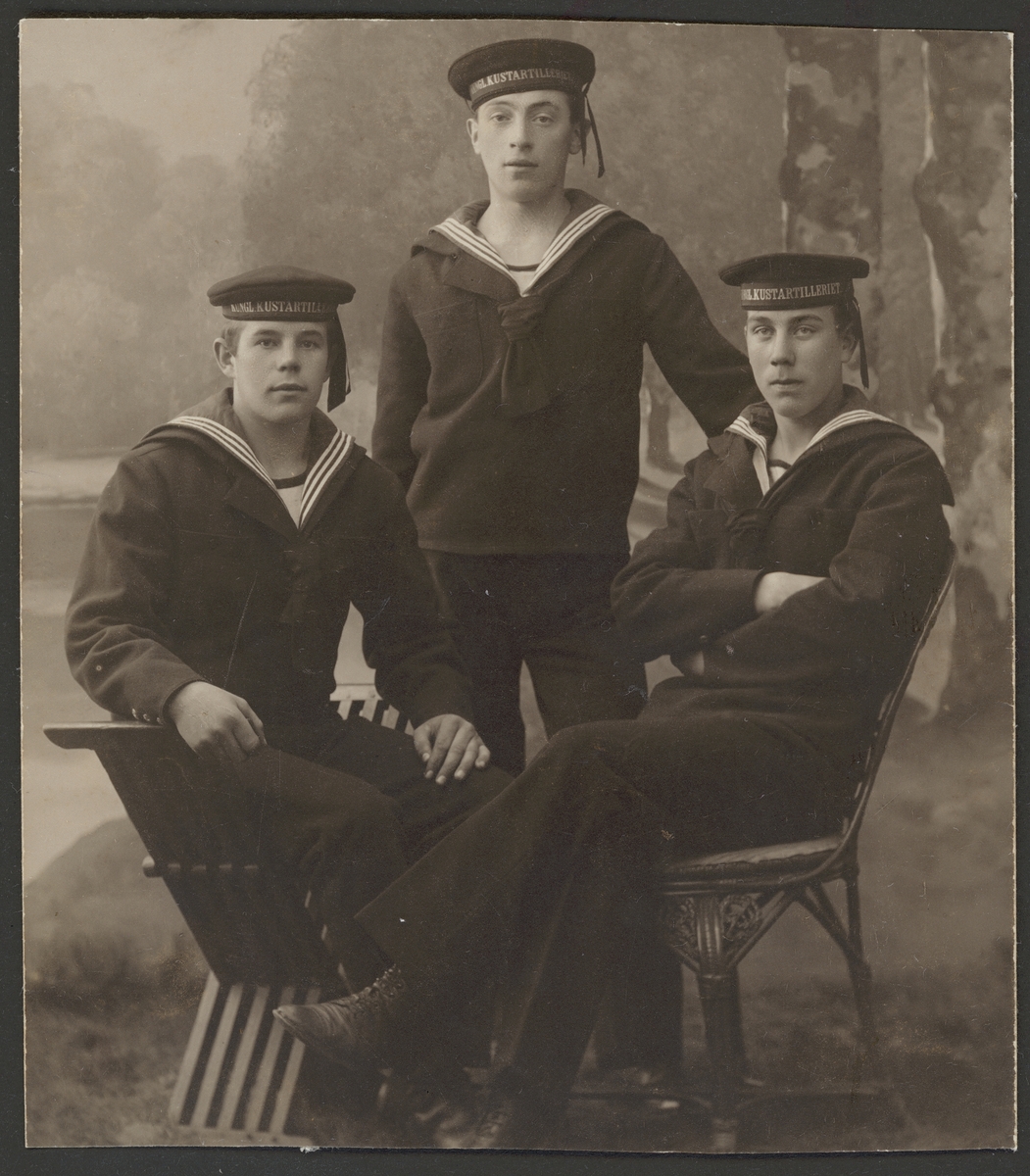 Bilden föreställer ett gruppfoto av tre sjömän från kustartilleriet klädd i sjömanskostymer.