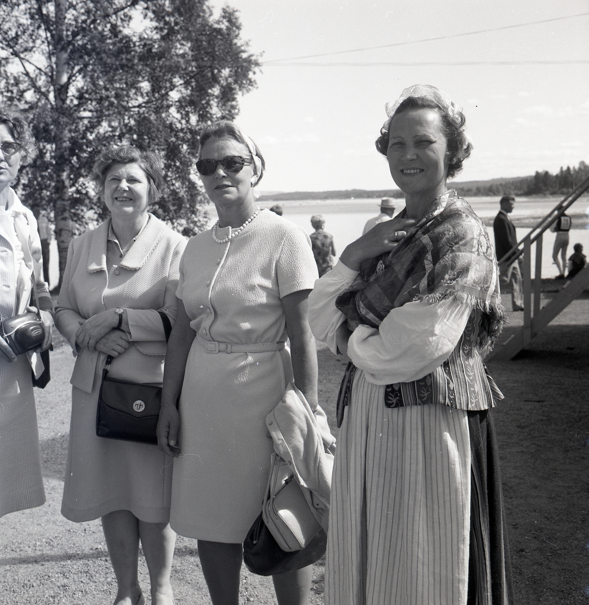 Fyra kvinnor som står vid en strand 1967. De tittar mot kameran.