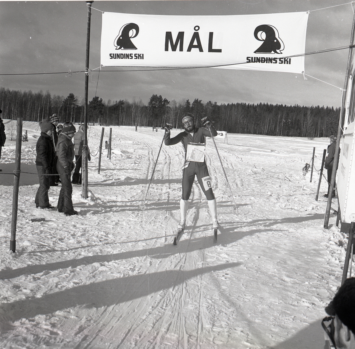 En skidåkare går i mål efter ett lopp i skidorintering.