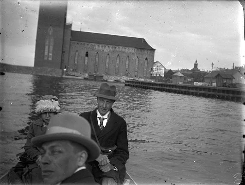 Två män och en kvinna i roddbåt på Riddarfjärden, Stockholm.