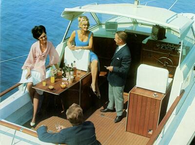 Pene mennesker om bord en åpen båt, med drinker og fint vær. Foto/Photo