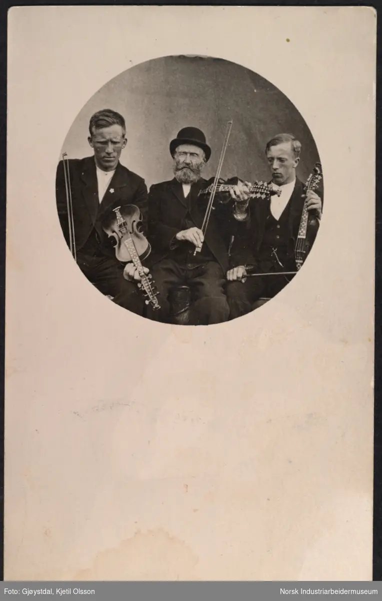 Spelemann Knut J. Dahle med barnebarn og spelemenn Gunnar og Johannes Dahle. Alle tre med fele i hånden.
