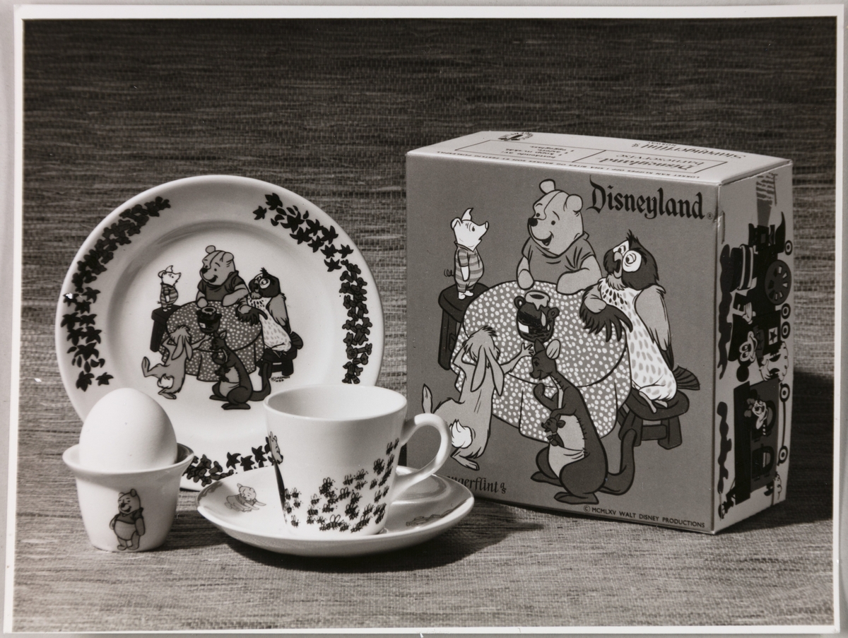 Barneserviset "Disneyland" fra Stavangerflint A/S. Avbildet sett viser en tallerken, en kopp med underskål og et eggeglass, med tilhørende gaveeske.